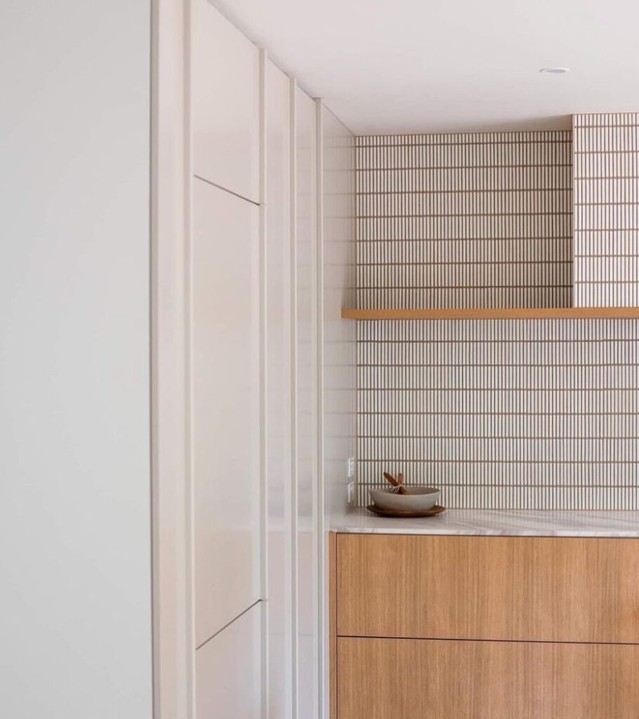 White tile splash back. Natural wooden kitchen drawers and large walk in cupboard.
