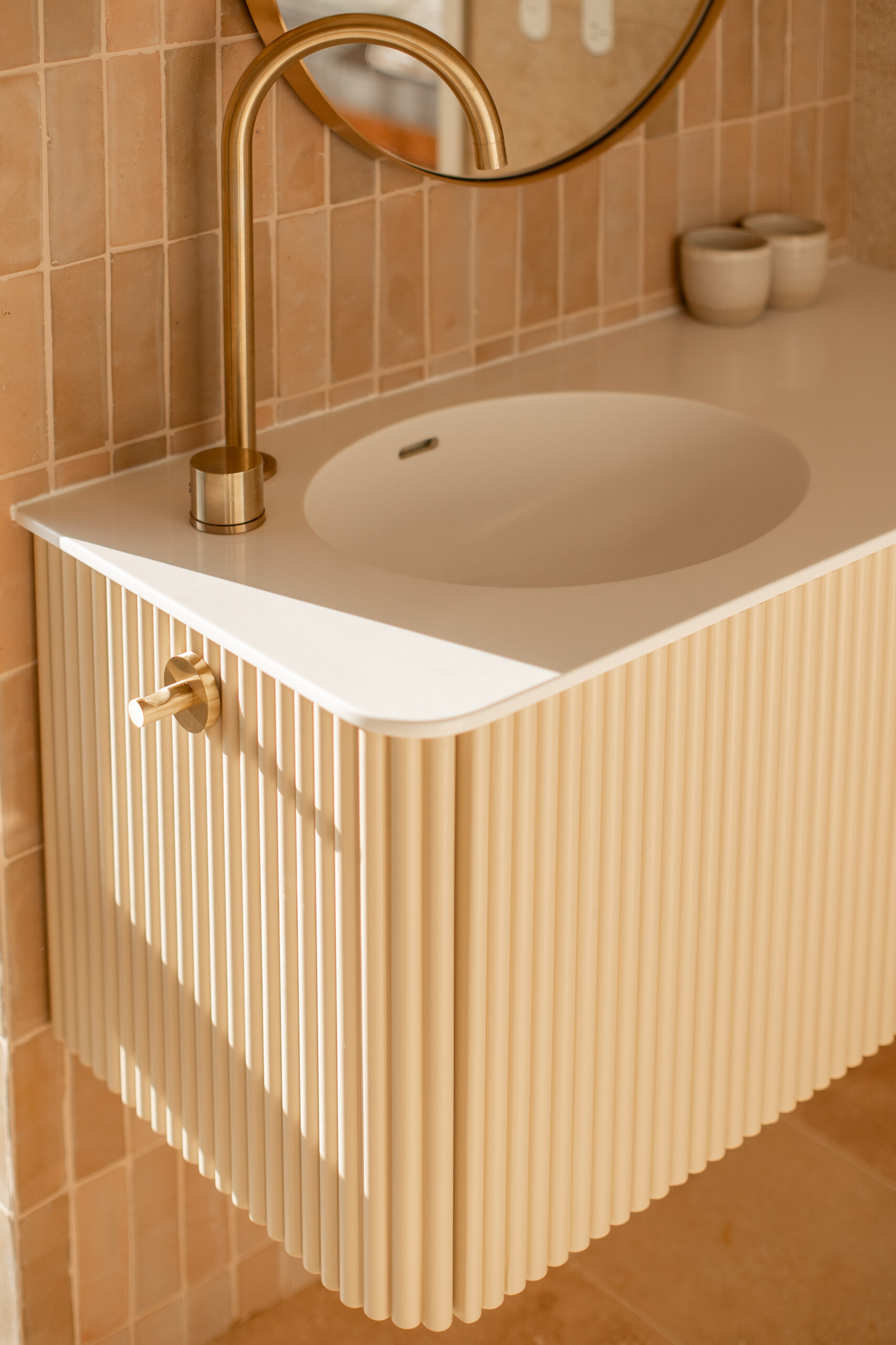 Custom curve vanity with ribbed finish and a corian top and basin. Angle one