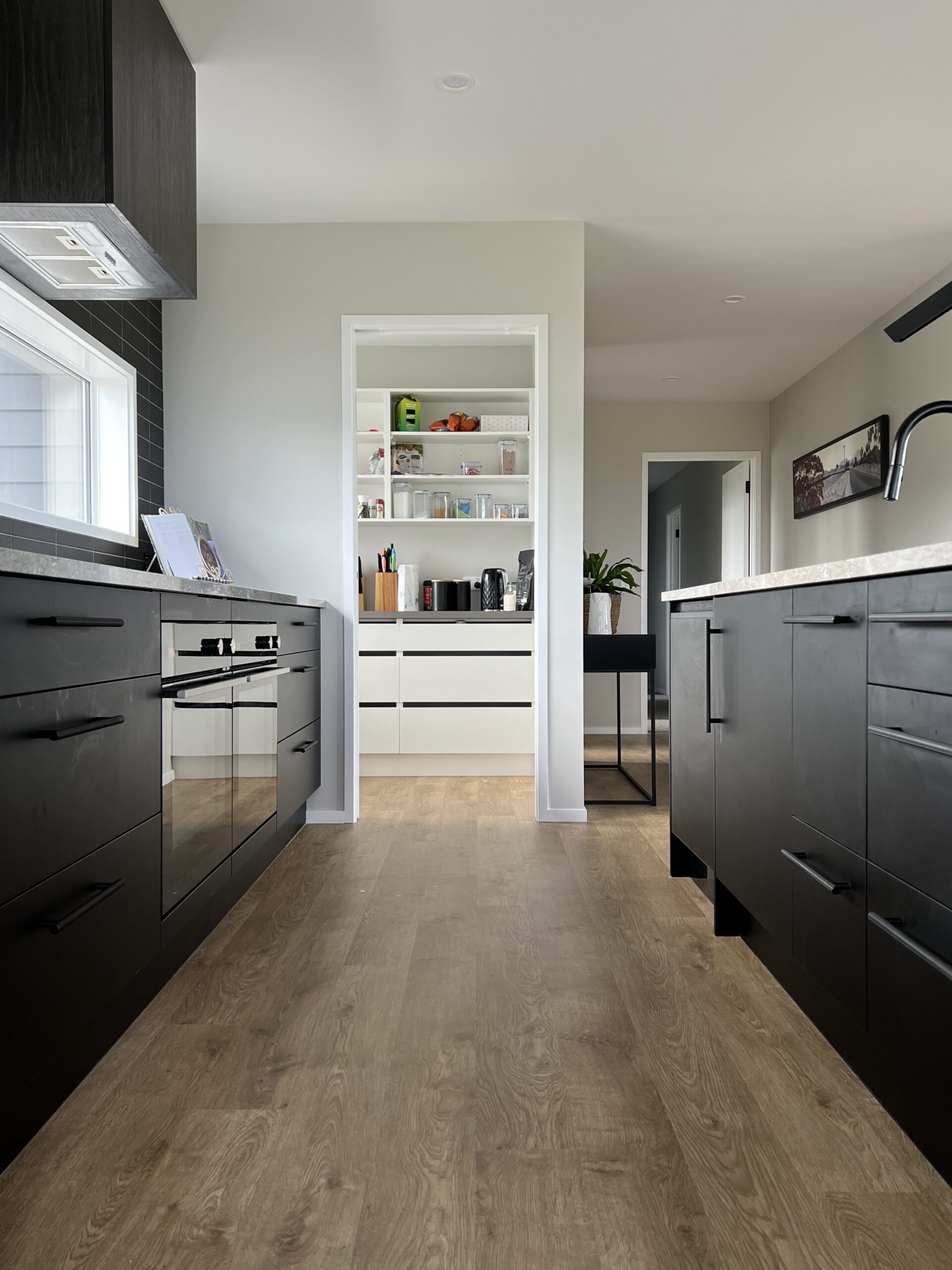 Matte black kitchen with a contrasting walk in that is all white.